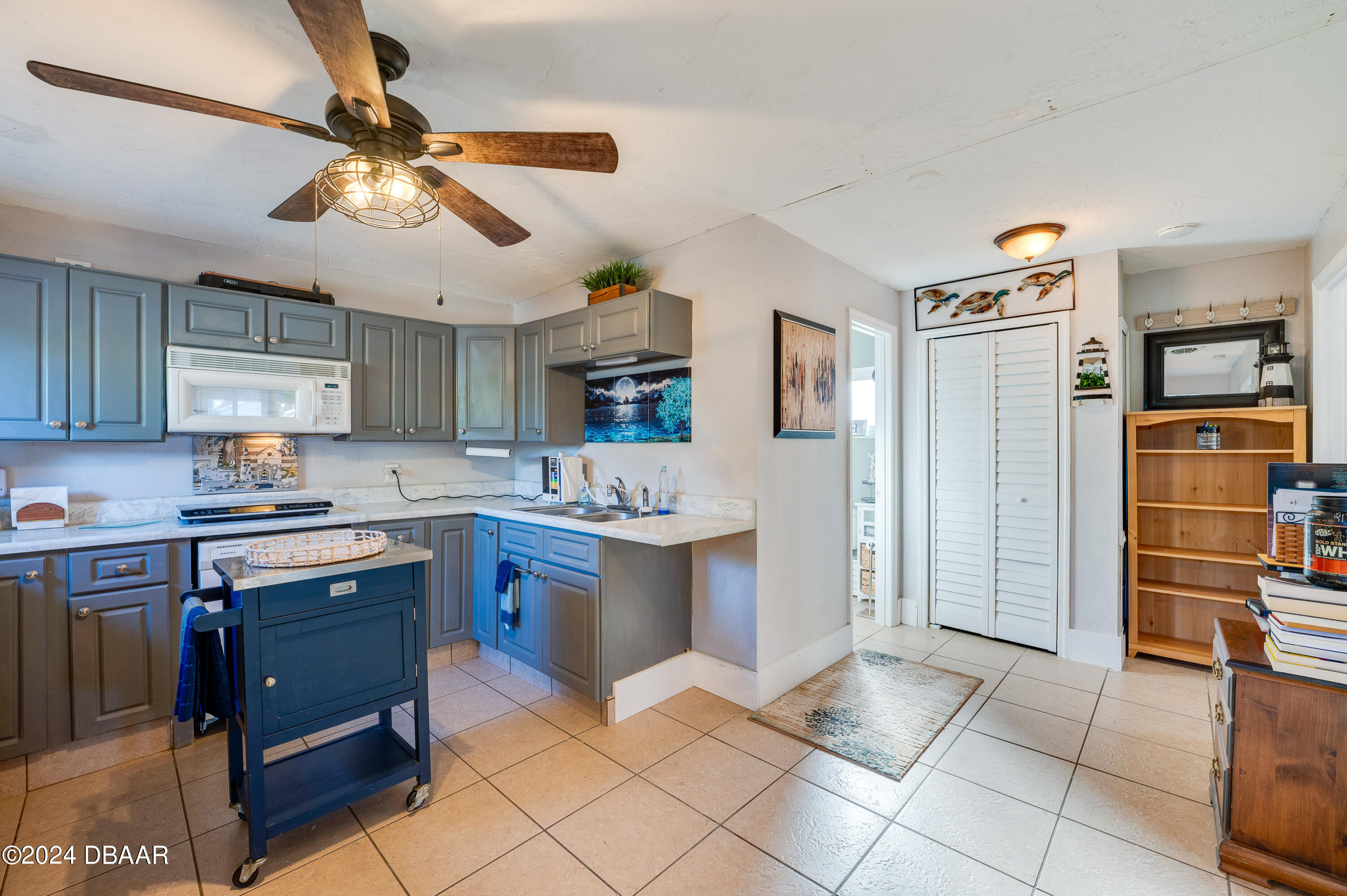 4850 Spruce Creek Road Port Orange, FL 32127 - Photo 20 of 27 a kitchen with a sink appliances and cabinets