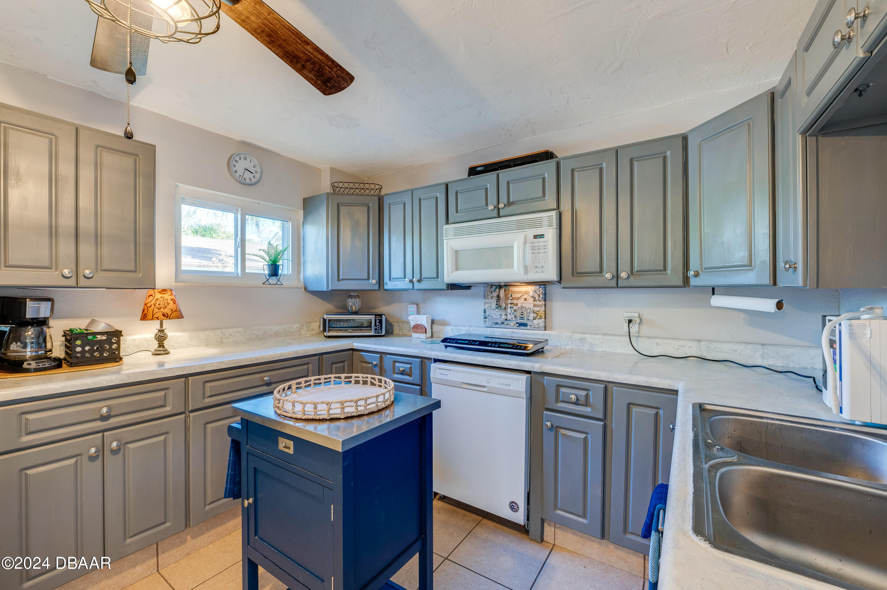 4850 Spruce Creek Road Port Orange, FL 32127 - Photo 21 of 27 a kitchen with a sink stove and cabinets