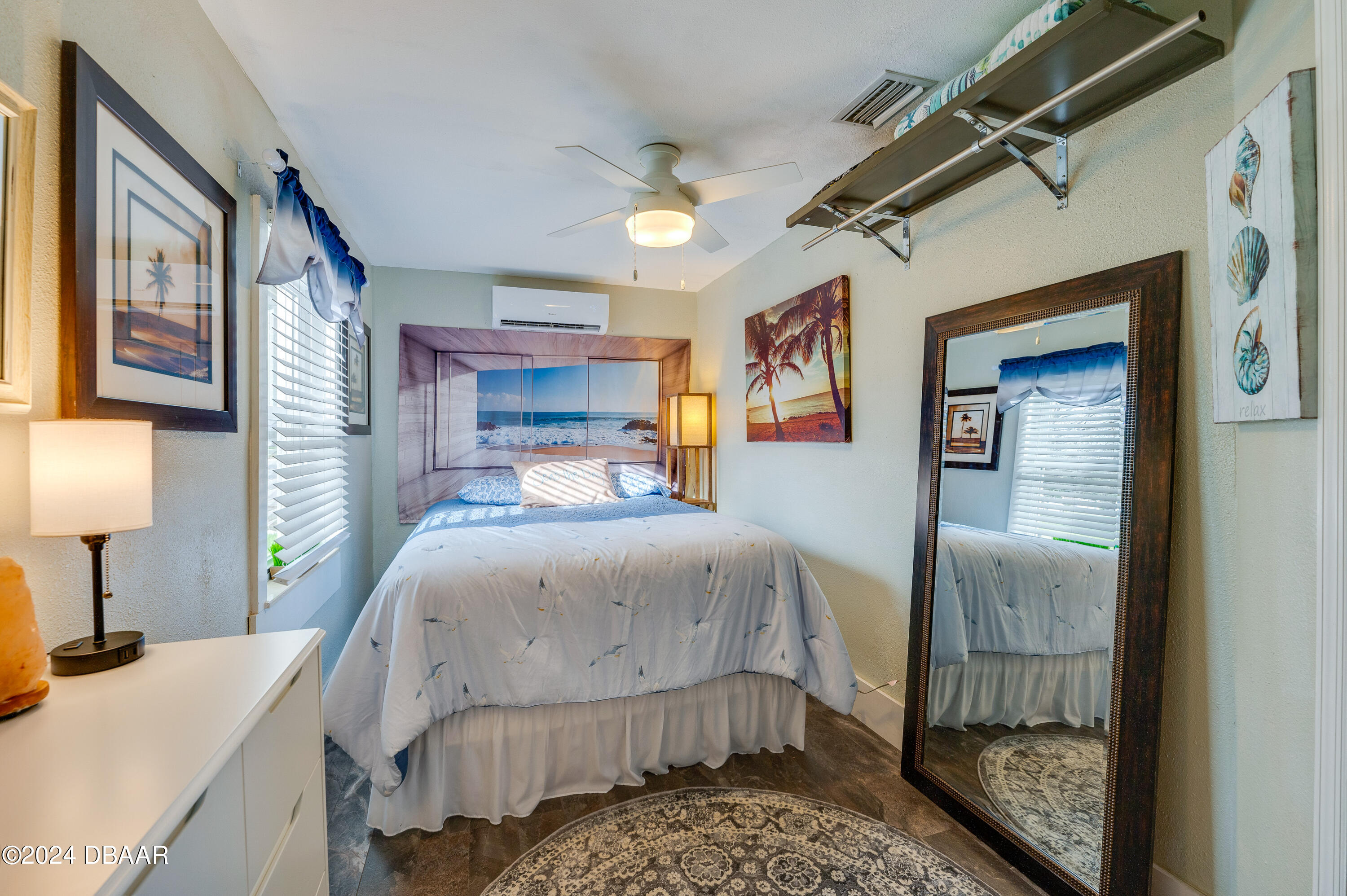 4850 Spruce Creek Road Port Orange, FL 32127 - Photo 22 of 27 a bedroom with a bed a mirror and lamp on table
