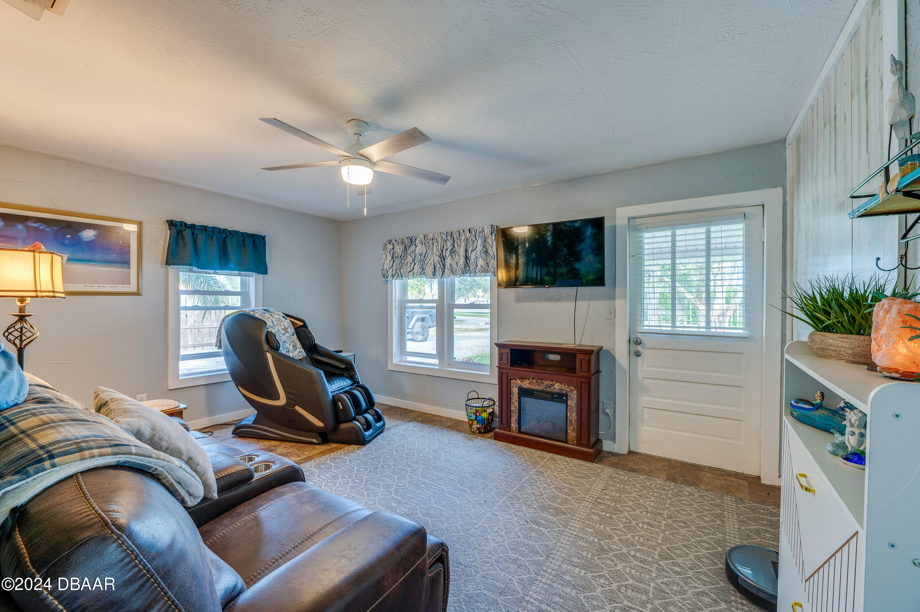 4850 Spruce Creek Road Port Orange, FL 32127 - Photo 6 of 27 a living room with furniture flat screen tv and a fireplace