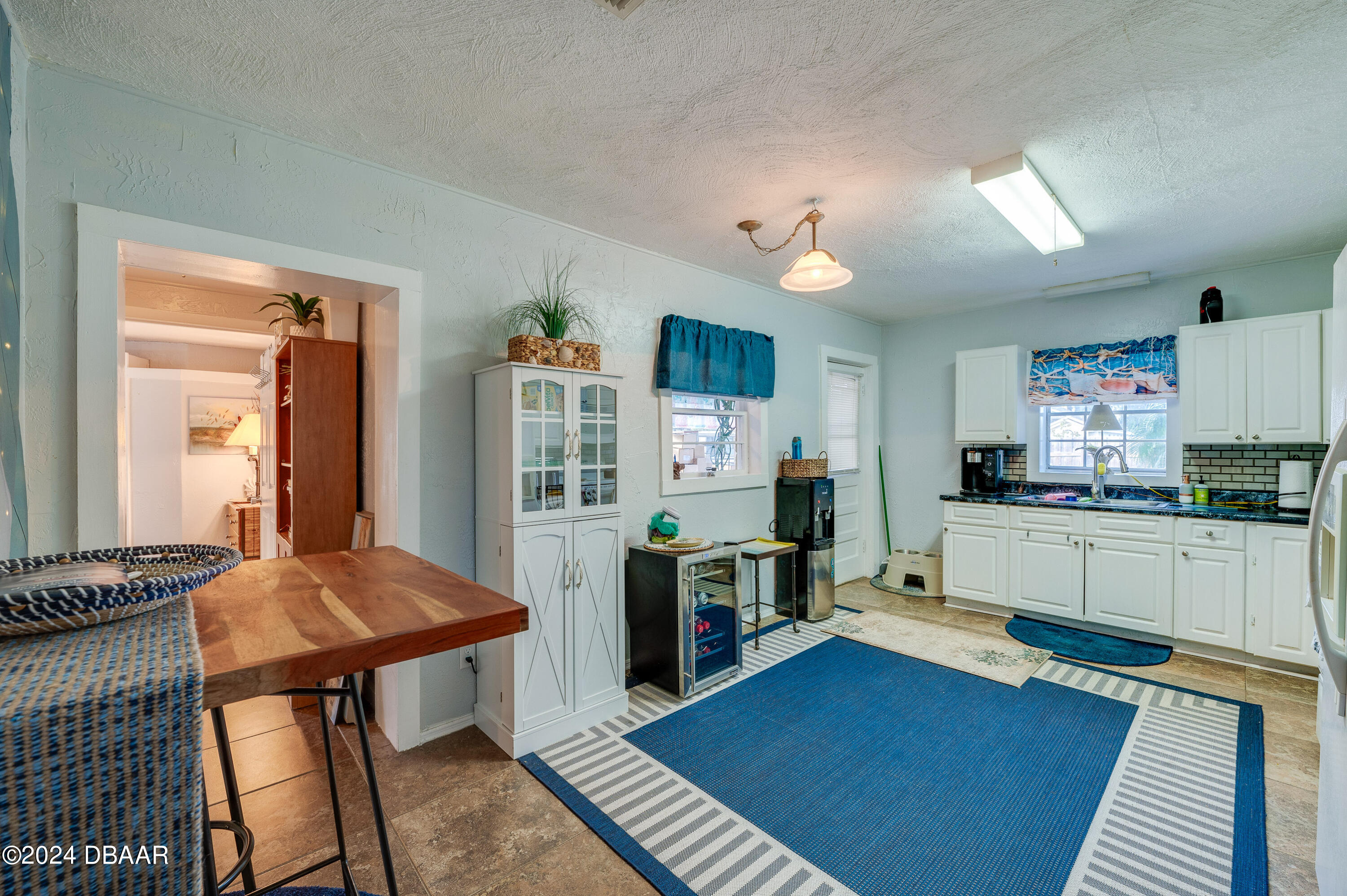 4850 Spruce Creek Road Port Orange, FL 32127 - Photo 7 of 27 a living room with furniture a flat screen tv and kitchen view