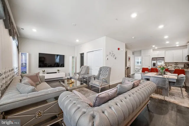 a living room with furniture kitchen view and a flat screen tv