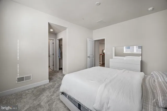 a bedroom with a bed and a refrigerator