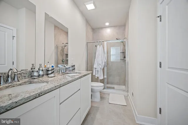 a bathroom with a granite countertop sink toilet and shower