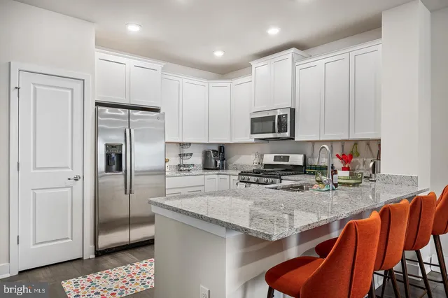 a kitchen with stainless steel appliances granite countertop a refrigerator and a stove top oven