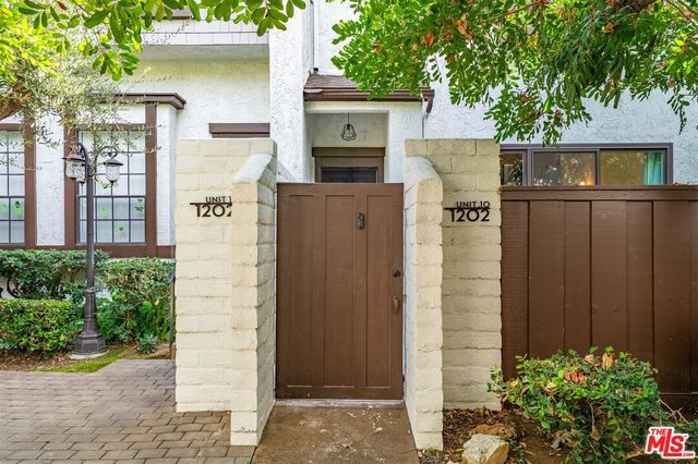 a front view of a house with plants