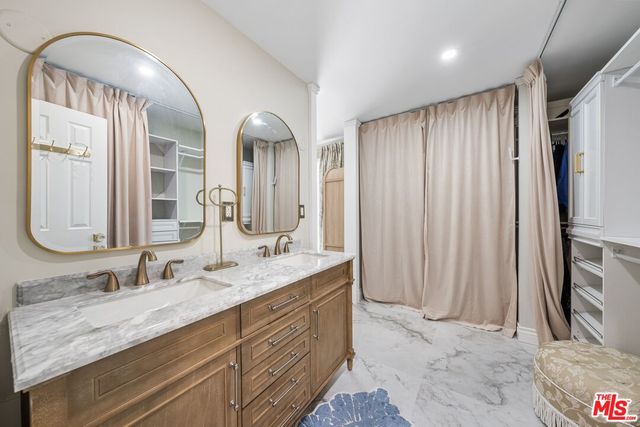a bathroom with double vanity and a mirror