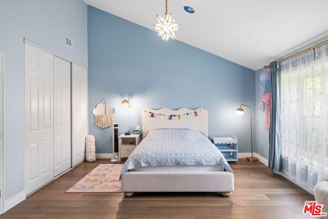 a bedroom with a bed and a chandelier