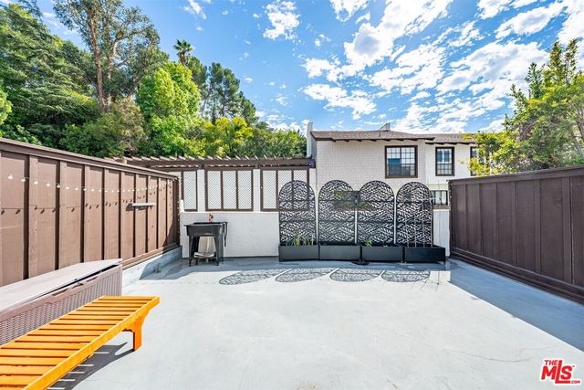 a view of a house with wooden fence and a large tree