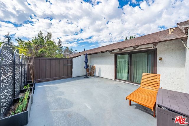 a backyard of a house with wooden fence and trees