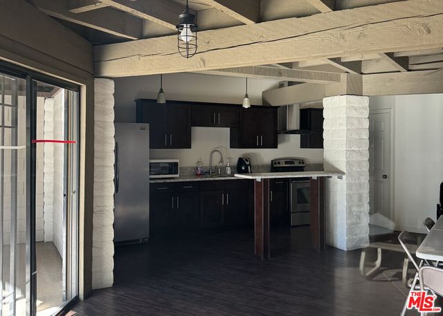 a patio with table and chairs and potted plants