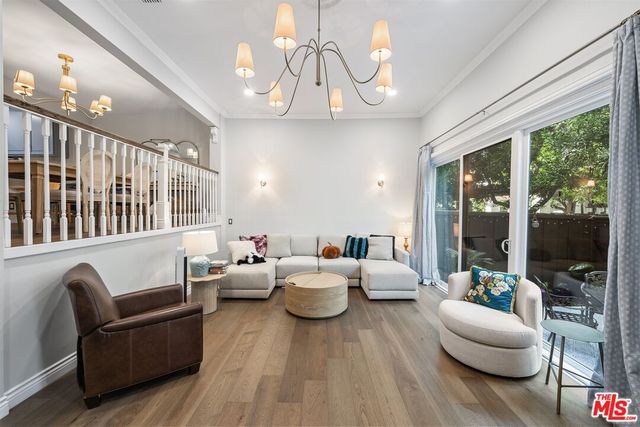 a living room with furniture chandelier and a large window