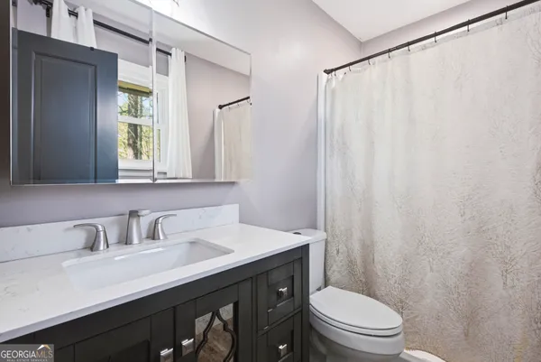 a bathroom with a sink a toilet and a mirror