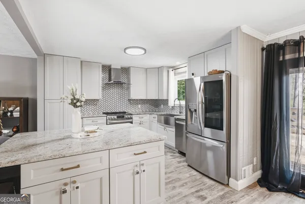 a kitchen with stainless steel appliances granite countertop a refrigerator and a sink