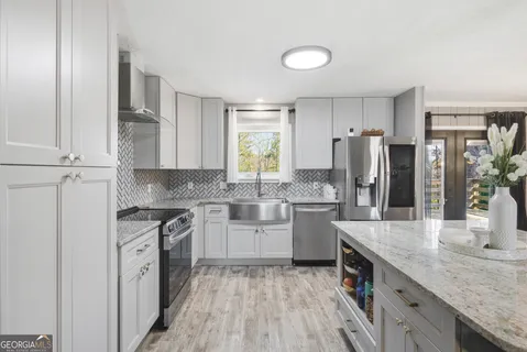 a kitchen with white cabinets and stainless steel appliances