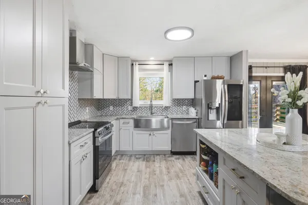 a kitchen with white cabinets and stainless steel appliances