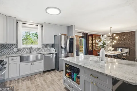 a kitchen with stainless steel appliances granite countertop a sink stove and refrigerator