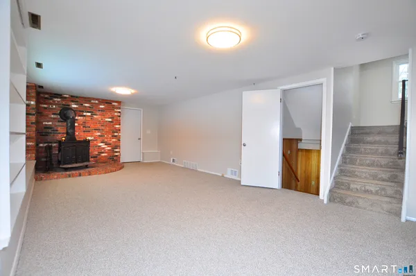 an empty room with a fireplace and window