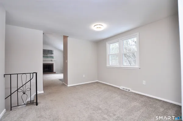 an empty room with a fireplace and entryway