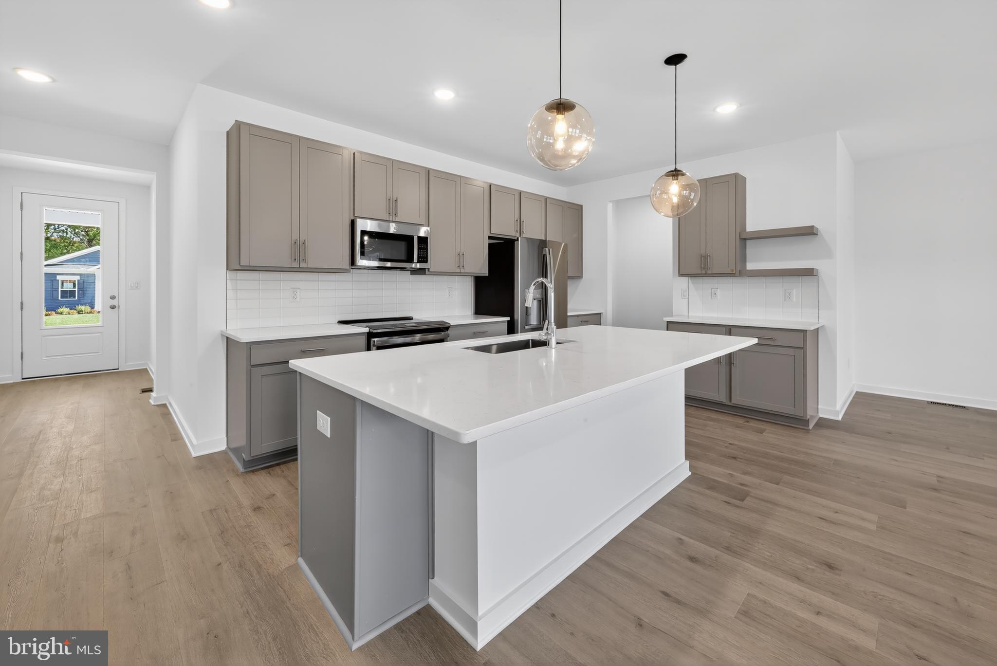14966 Channel Run Ellendale, DE 19941 - Photo 4 of 21 a kitchen with a sink a counter top space stainless steel appliances and a window