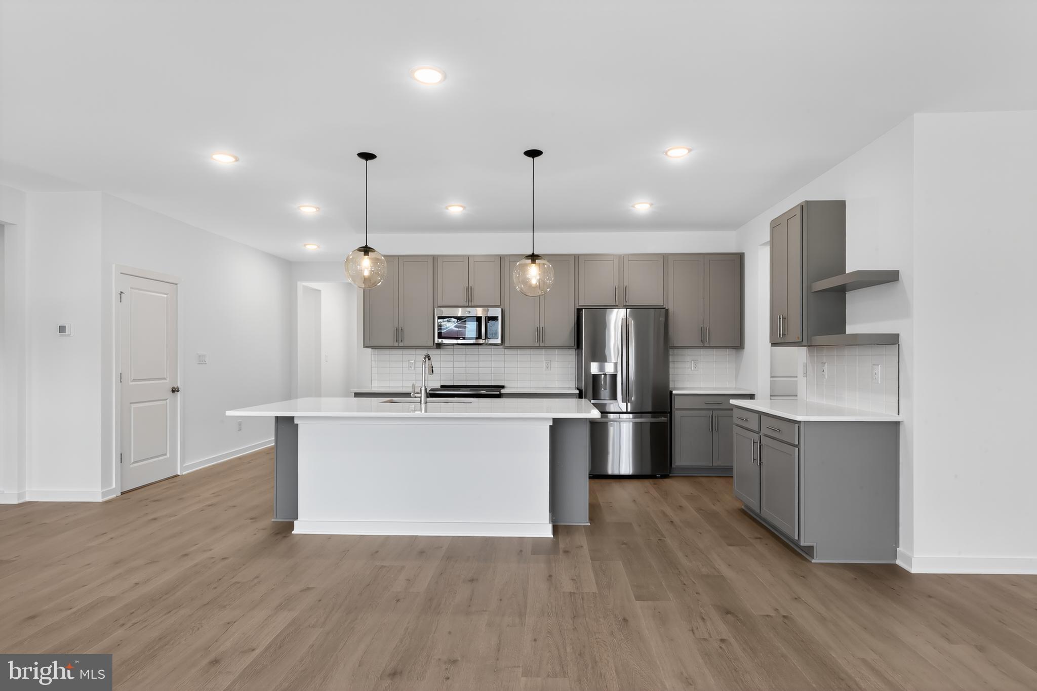 14966 Channel Run Ellendale, DE 19941 - Photo 6 of 21 a kitchen with stainless steel appliances kitchen island a sink and a refrigerator