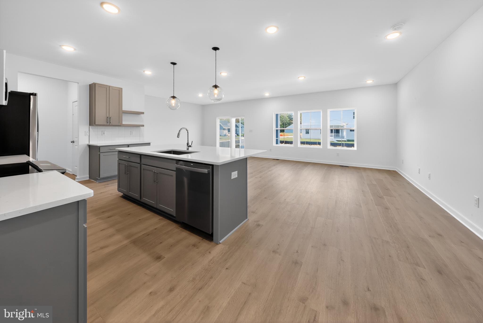 14966 Channel Run Ellendale, DE 19941 - Photo 7 of 21 a large kitchen with stainless steel appliances granite countertop a large counter top and a wooden floors
