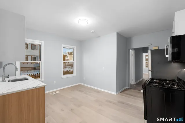 a view of a kitchen with stainless steel appliances granite countertop a stove and a sink
