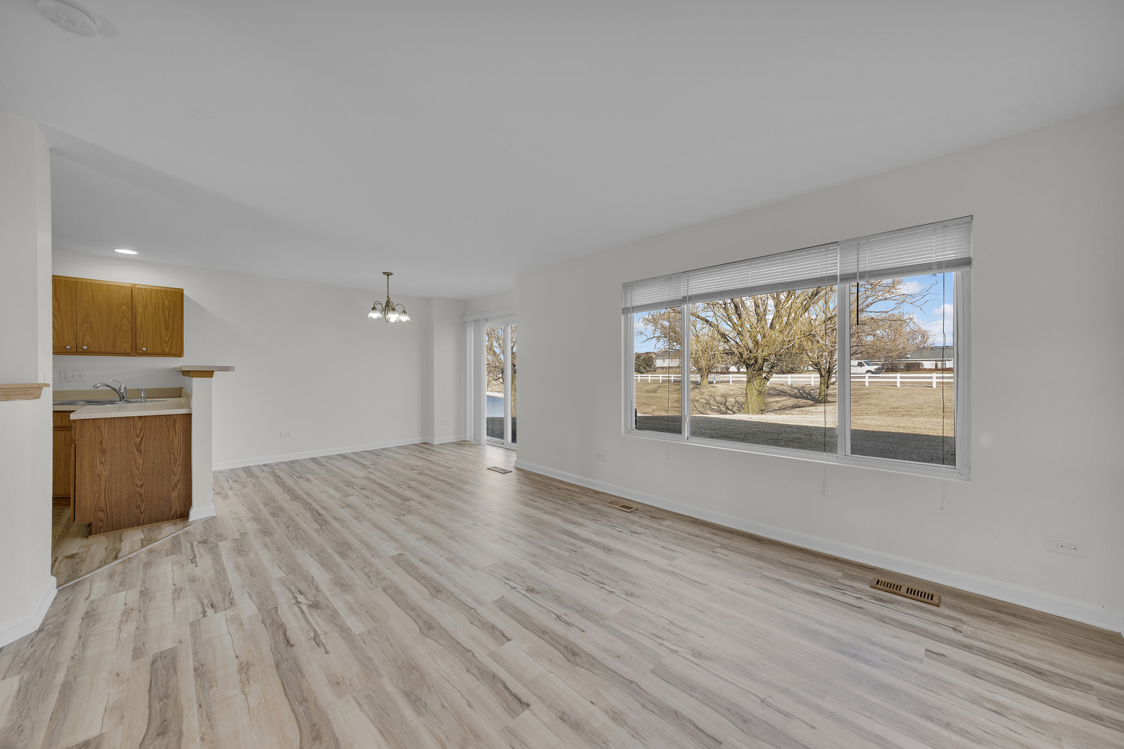 608 Chestnut Ridge Minooka, IL 60447 - Photo 8 of 16 an empty room with wooden floor and windows