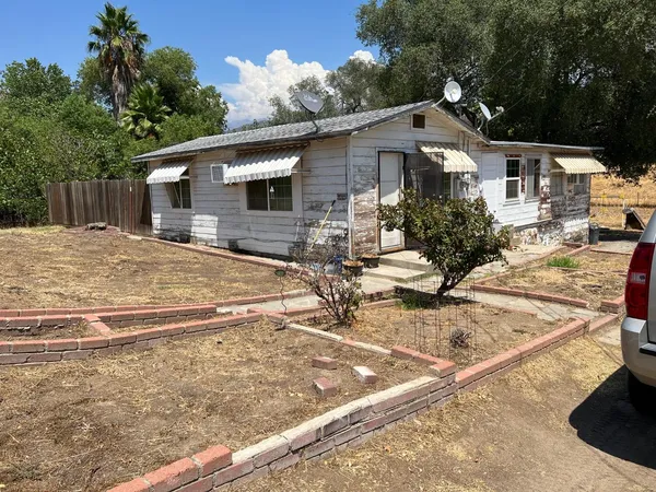 a view of a house with backyard and sitting area