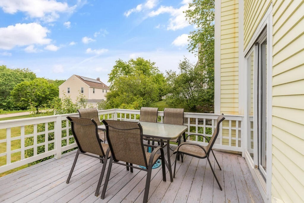 6 Pear Tree Drive Canton, MA 02021 - Photo 28 of 33 a view of a deck with table and chairs with wooden floor and fence