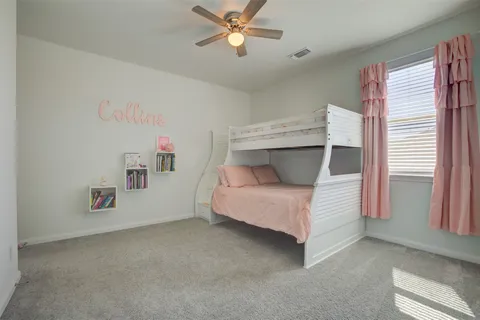 a bedroom with a bed and a ceiling fan