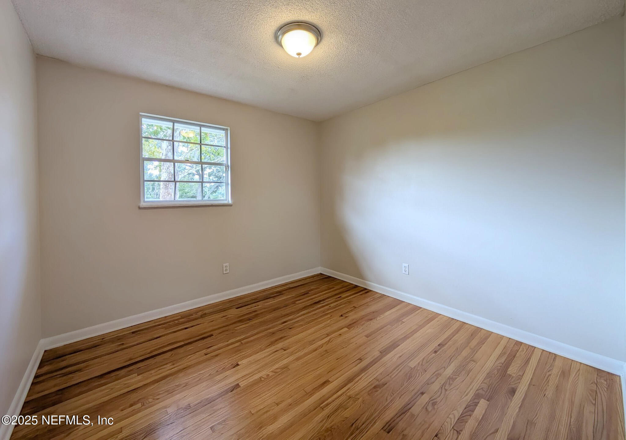 5091 Somersby Road Jacksonville, FL 32217 - Photo 10 of 19 an empty room with wooden floor and windows