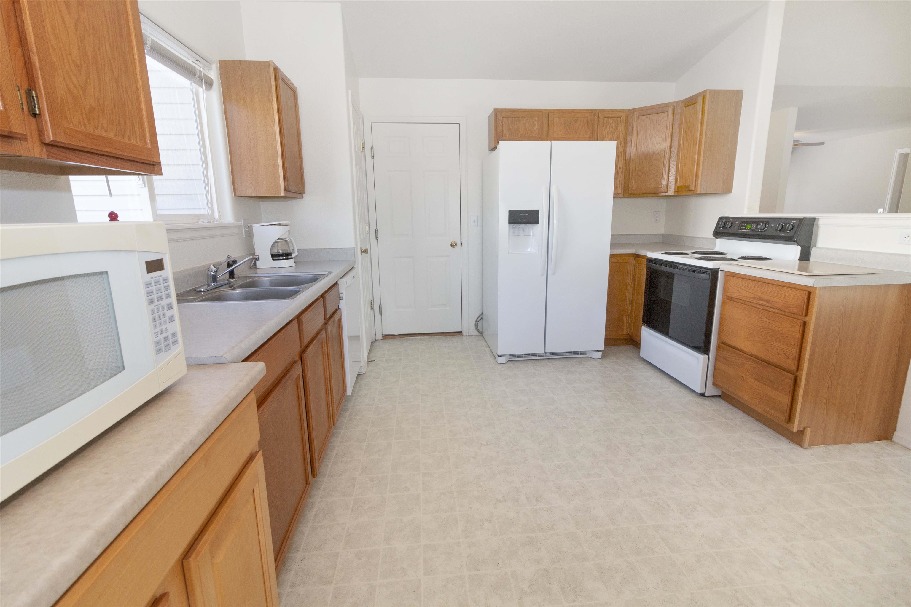 1386 Powell Street Fruita, CO 81521 - Photo 7 of 21 a kitchen with stainless steel appliances granite countertop a stove a sink and a refrigerator