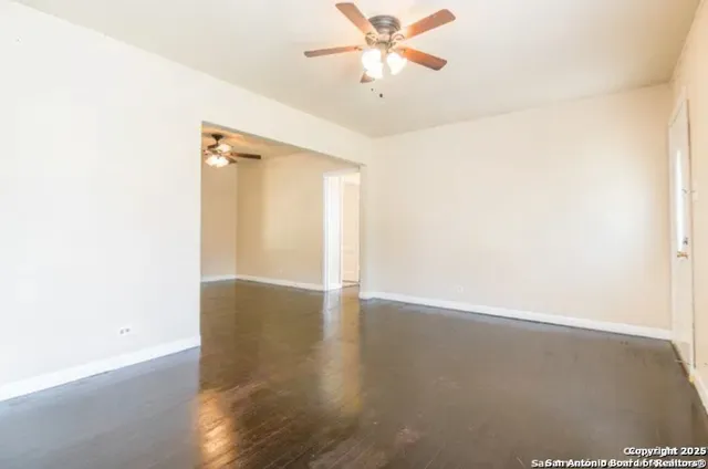 a view of an empty room with wooden floor