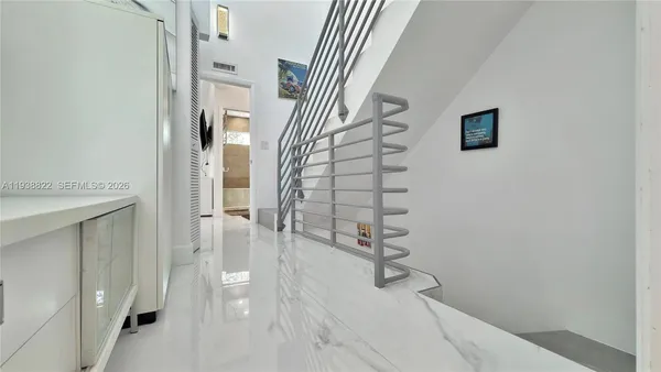 a view of a hallway with wooden floor and staircase