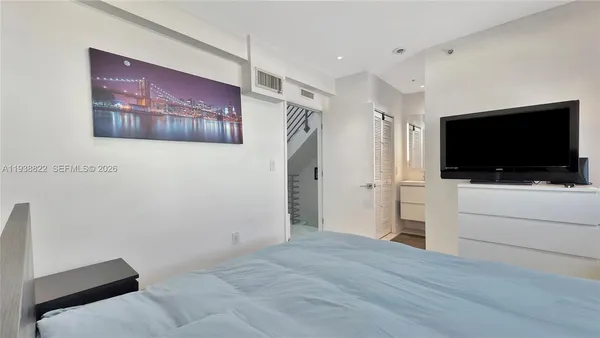 a view of a livingroom with wooden floor and flat screen tv
