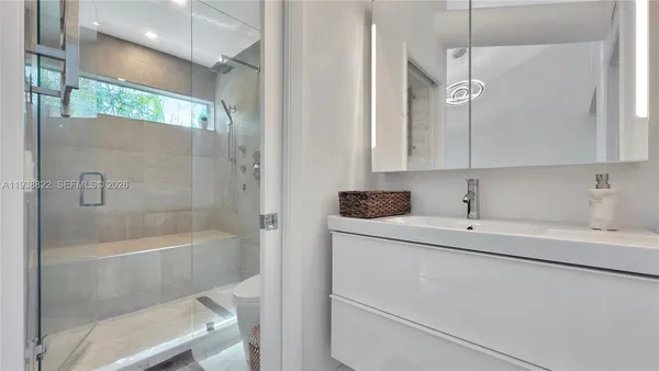 a bathroom with a sink a toilet and shower