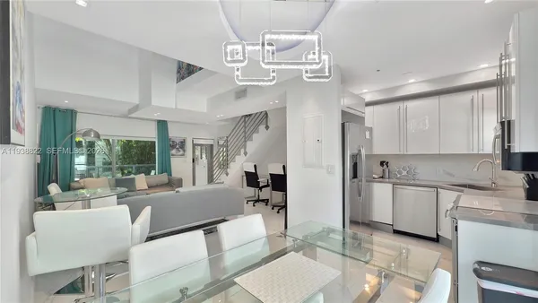 a large living room with stainless steel appliances granite countertop furniture a fireplace and a large window