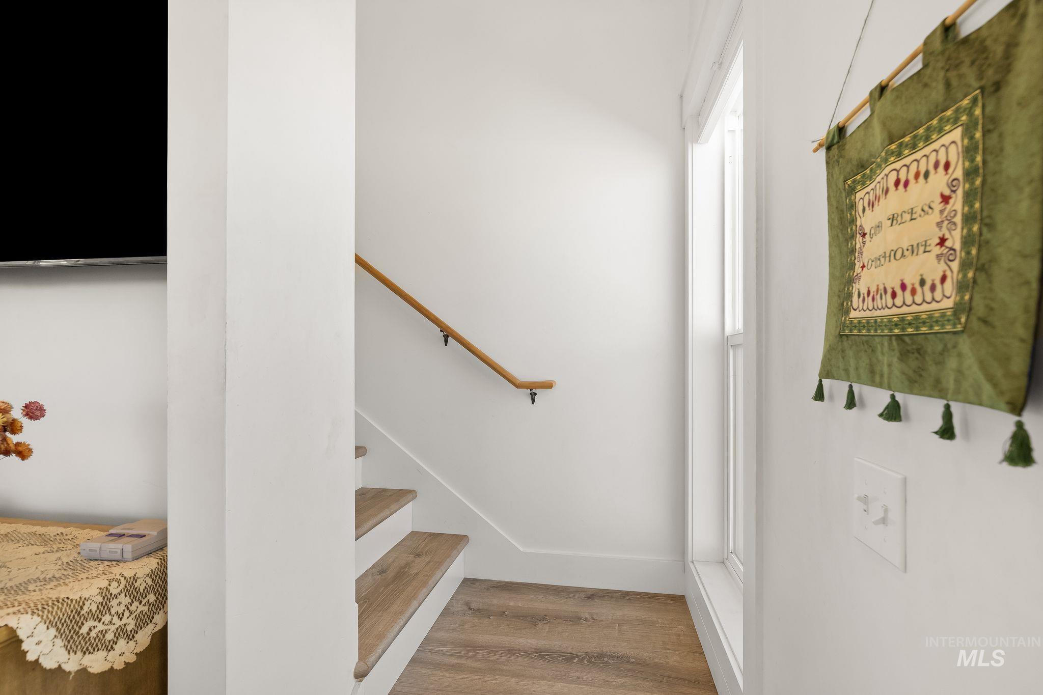 4935 Lenville Road Moscow, ID 83843 - Photo 25 of 49 Staircase featuring wood-finish treads, white risers, and a natural wood handrail