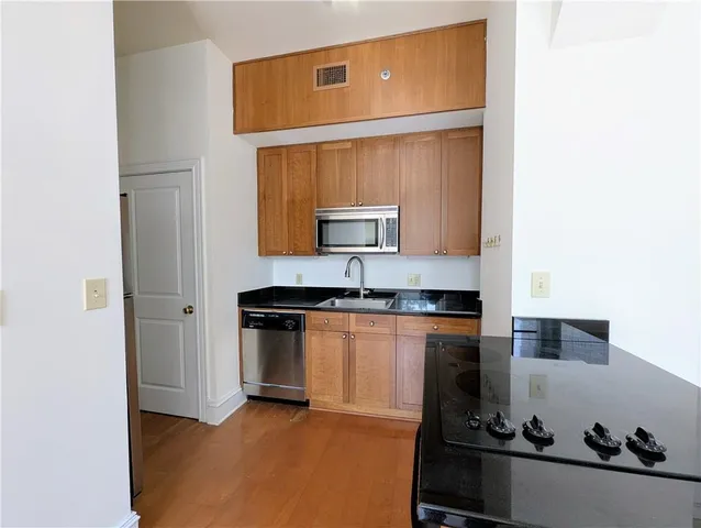 a kitchen with stainless steel appliances granite countertop a sink stove and cabinets