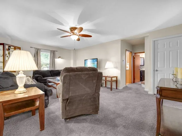 a living room with furniture a ceiling fan and a window