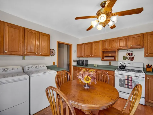 a kitchen with a dining table chairs and a refrigerator