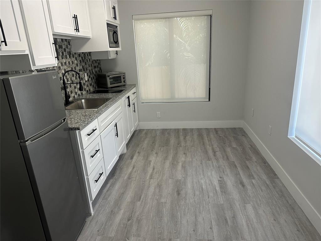 1639 Madison Street, Unit 11B Hollywood, FL 33020 - Photo 4 of 8 a kitchen with granite countertop white cabinets and white appliances