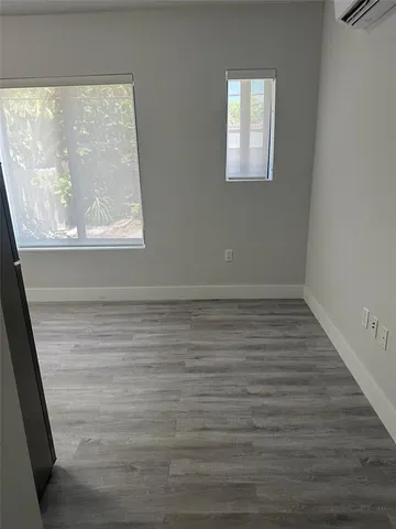 a view of a small space with wooden floor and a window