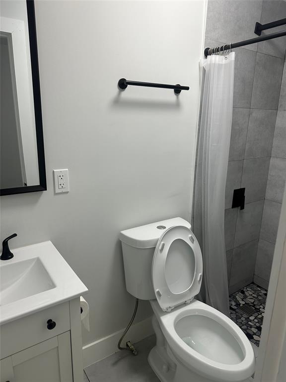 1639 Madison Street, Unit 11B Hollywood, FL 33020 - Photo 6 of 8 a bathroom with a toilet a sink and a mirror