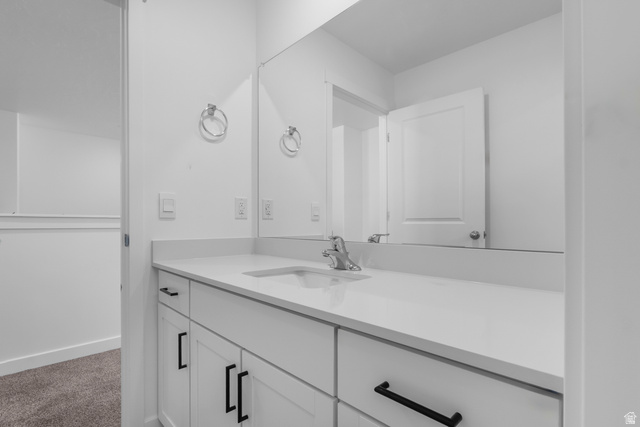 1355 West 2350 South, Unit 11 Perry, UT 84302 - Photo 25 of 39 Bathroom vanity featuring a quartz countertop, integrated rectangular sink, chrome faucet, and matte black cabinet hardware