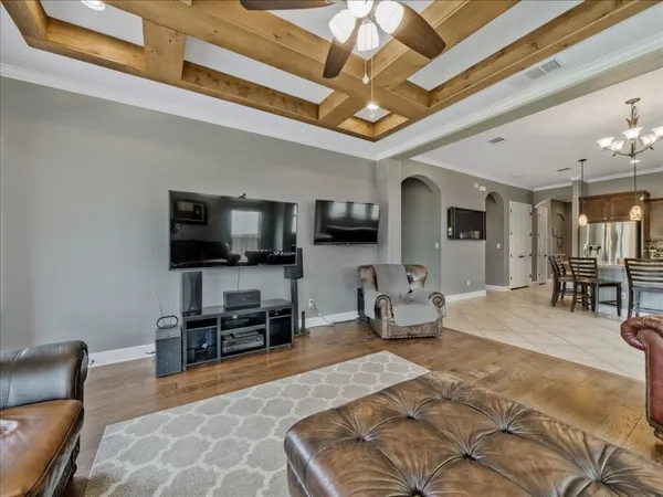 a living room with furniture a flat screen tv and a large window