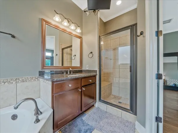 a bathroom with a tub sink and mirror