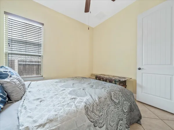a bedroom with a bed and a chandelier fan