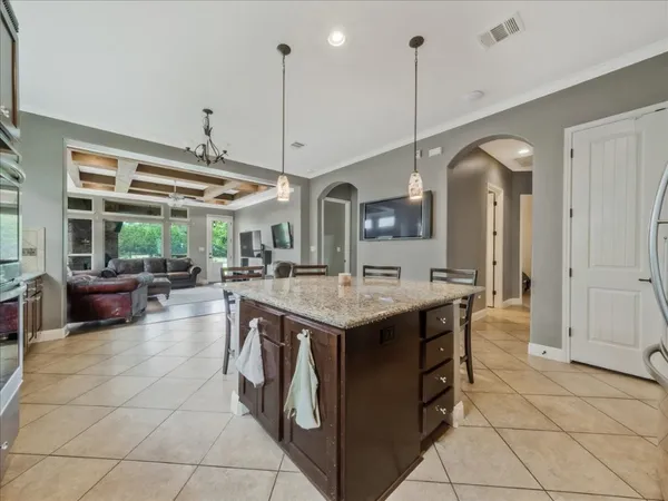 a open kitchen with stainless steel appliances granite countertop a stove and a view of living room